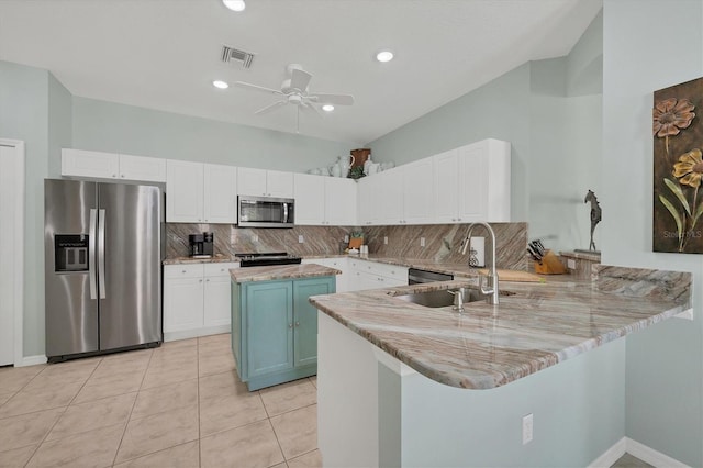 kitchen with kitchen peninsula, appliances with stainless steel finishes, and white cabinets