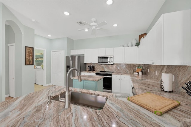 kitchen featuring white cabinets, backsplash, sink, and appliances with stainless steel finishes