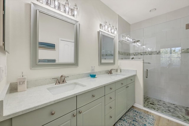 bathroom featuring vanity, a shower with shower door, and wood-type flooring