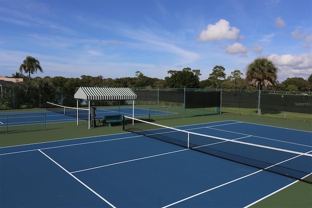 view of tennis court featuring basketball hoop