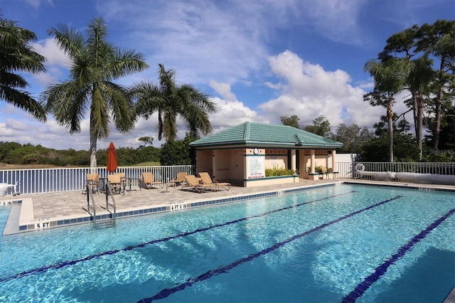 view of swimming pool featuring a patio area and an outbuilding