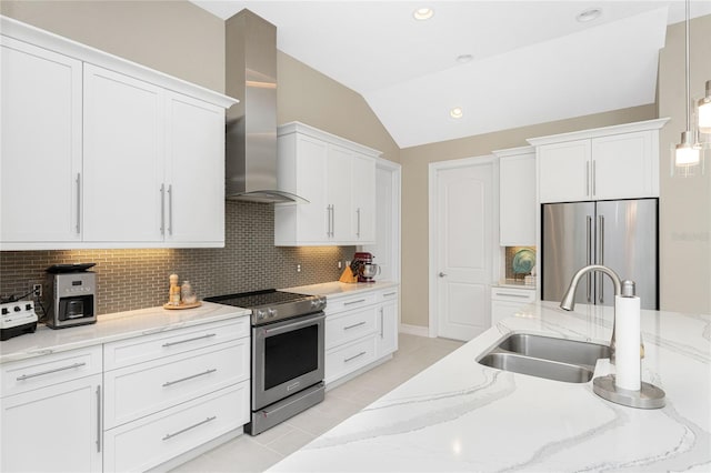 kitchen featuring white cabinetry, wall chimney exhaust hood, pendant lighting, lofted ceiling, and appliances with stainless steel finishes