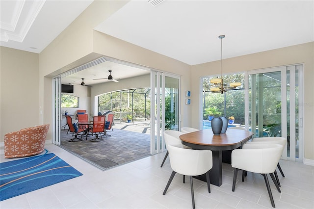 tiled dining room featuring ceiling fan with notable chandelier and a healthy amount of sunlight