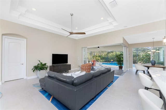 tiled living room featuring crown molding and a tray ceiling