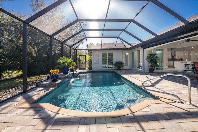 view of swimming pool with pool water feature, ceiling fan, a lanai, area for grilling, and a patio area