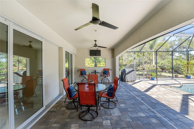 view of patio with a lanai, a grill, and ceiling fan