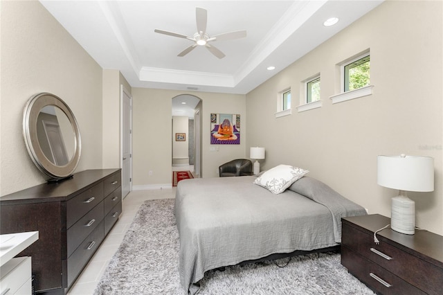 tiled bedroom featuring a raised ceiling and ceiling fan