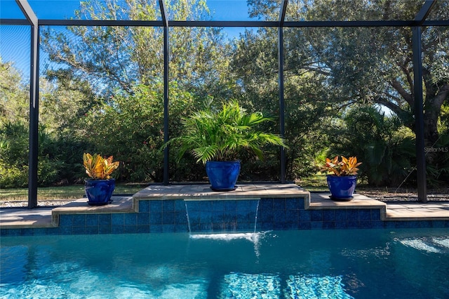 view of swimming pool featuring a lanai and pool water feature