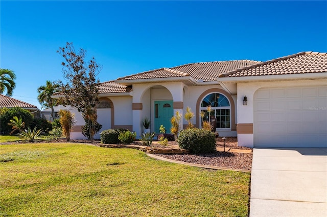 mediterranean / spanish house with a garage and a front yard