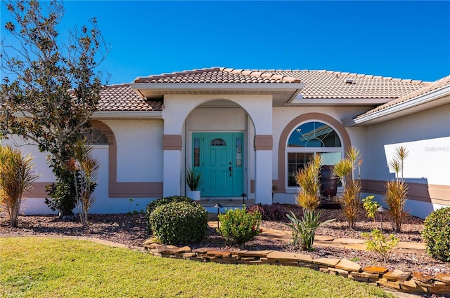 entrance to property featuring a lawn