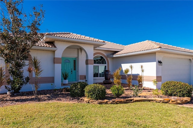 mediterranean / spanish home with a front yard and a garage