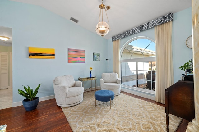 living area featuring vaulted ceiling and hardwood / wood-style floors