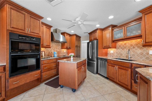 kitchen featuring light tile patterned floors, appliances with stainless steel finishes, wall chimney range hood, a kitchen island, and sink