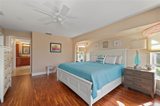 bedroom with ceiling fan, dark wood-type flooring, and ensuite bath