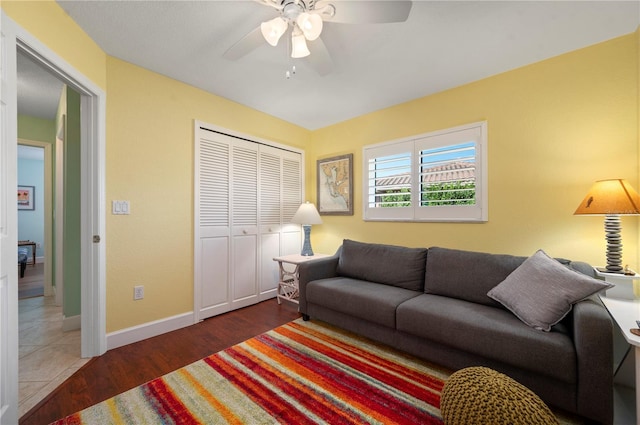 living room featuring ceiling fan and dark hardwood / wood-style flooring