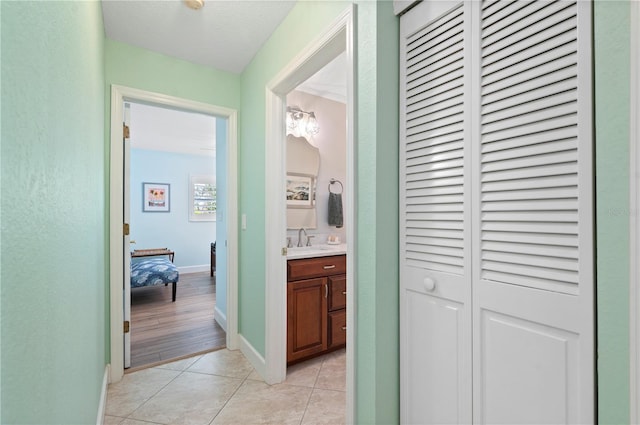 hall featuring light tile patterned floors and sink