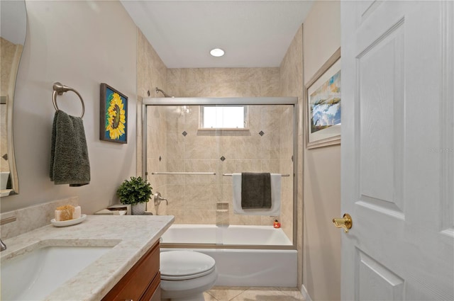 full bathroom featuring toilet, bath / shower combo with glass door, tile patterned floors, and vanity