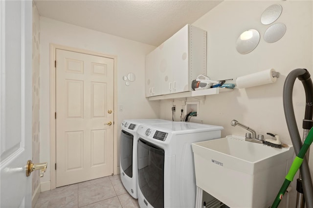 washroom featuring sink, a textured ceiling, and washing machine and clothes dryer