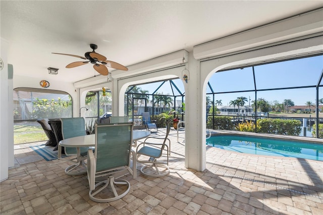 view of swimming pool with ceiling fan, a lanai, and a patio area