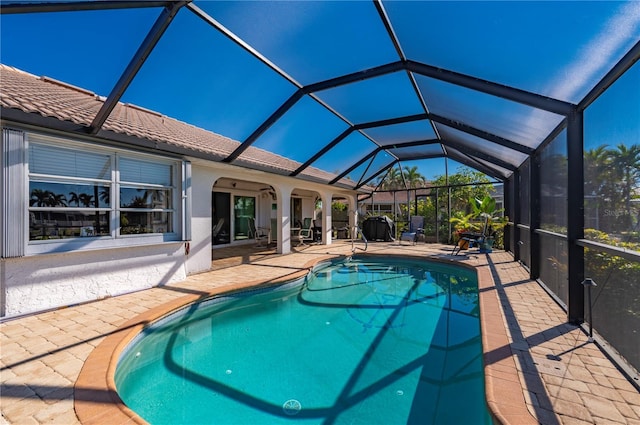 view of swimming pool featuring a lanai and a patio area