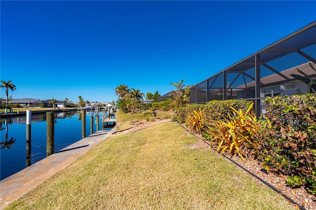 view of yard with a boat dock, a lanai, and a water view