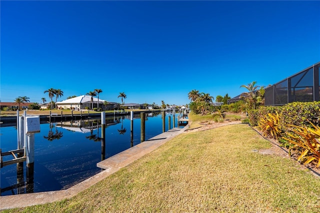 dock area with a water view, a yard, and a lanai