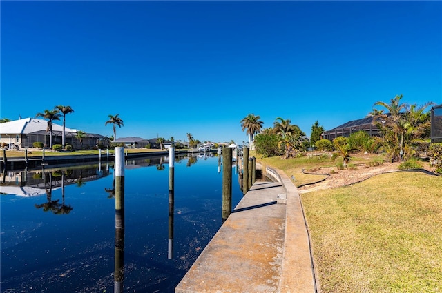 dock area with a lawn and a water view