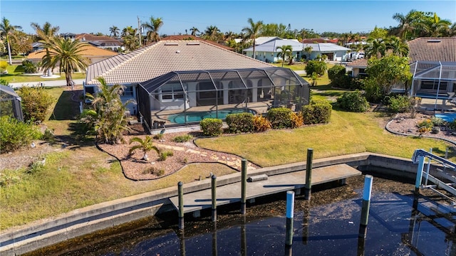 rear view of house with a lanai and a lawn