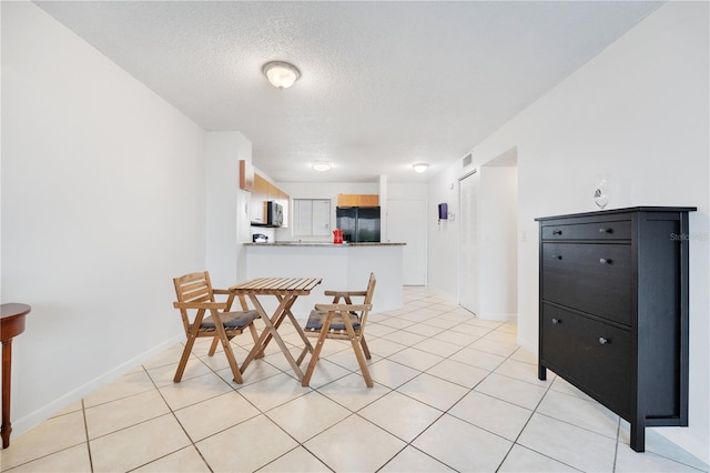 dining space featuring light tile patterned floors and a textured ceiling