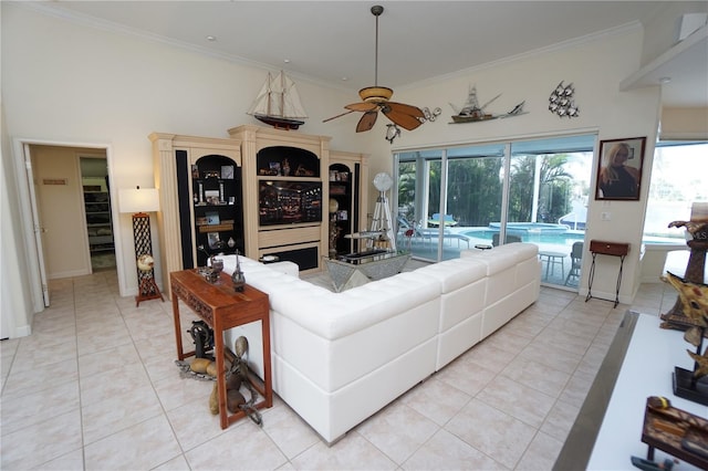 tiled living room featuring a high ceiling, ceiling fan, and crown molding