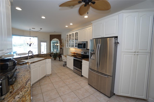 kitchen with dark stone countertops, sink, white cabinets, and appliances with stainless steel finishes