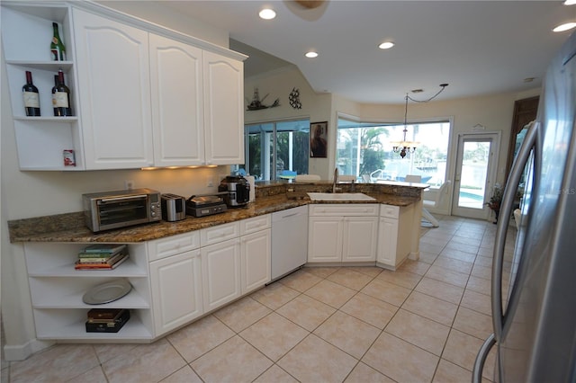 kitchen with white dishwasher, white cabinetry, dark stone counters, and sink