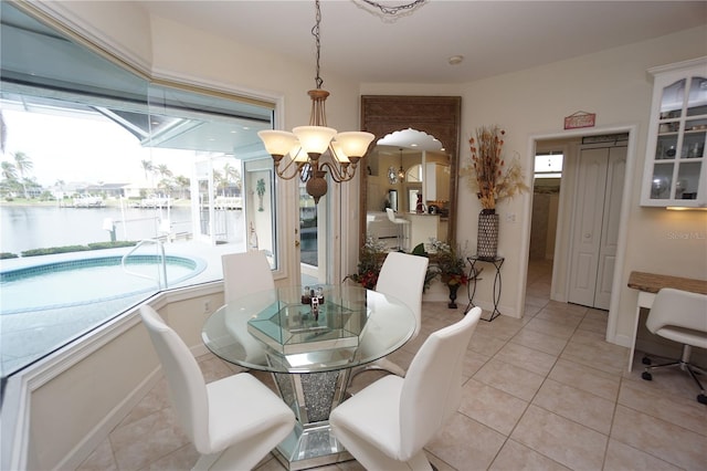 tiled dining area featuring a water view and an inviting chandelier