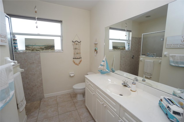 bathroom with tile patterned flooring, a tile shower, vanity, and toilet