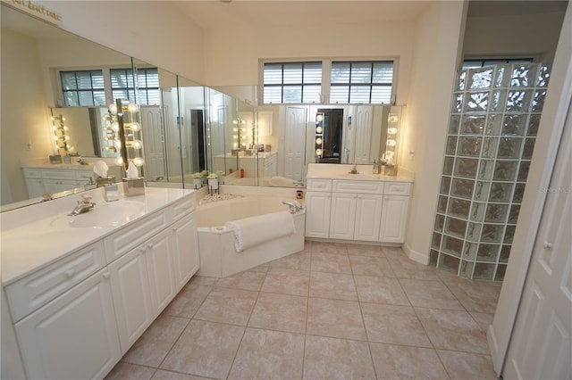 bathroom featuring tile patterned flooring, a bathtub, vanity, and an inviting chandelier