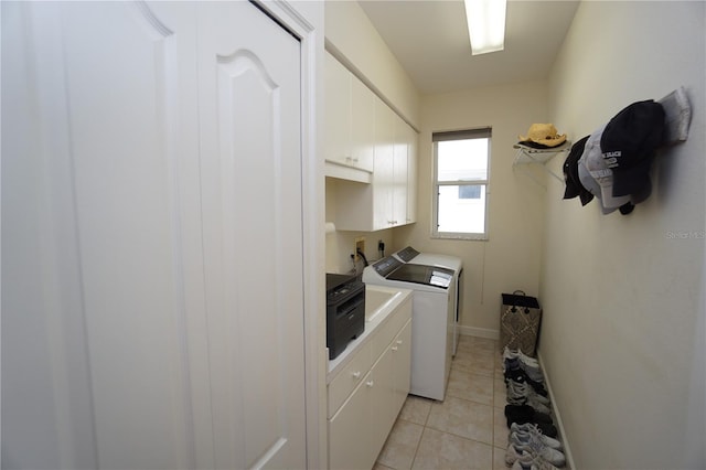 laundry area with cabinets, light tile patterned floors, and washer and clothes dryer