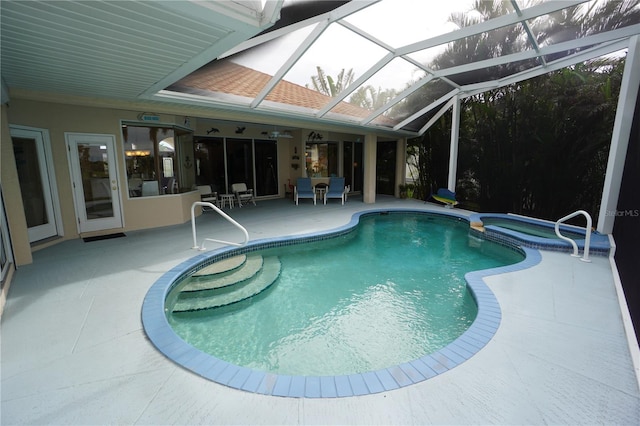 view of swimming pool with an in ground hot tub, a patio, and glass enclosure