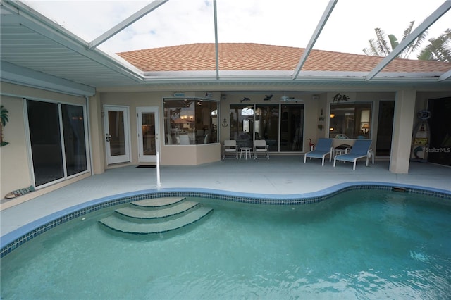 view of swimming pool with a patio area and glass enclosure