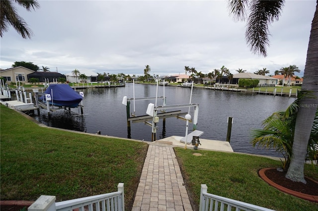 view of dock with a water view and a yard