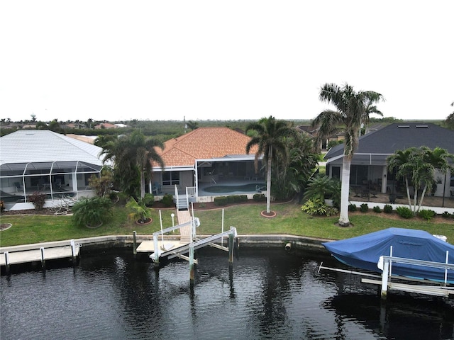 view of dock with glass enclosure, a yard, and a water view