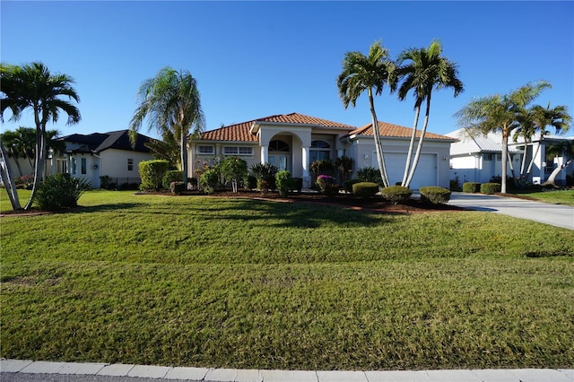 mediterranean / spanish home featuring a front lawn and a garage