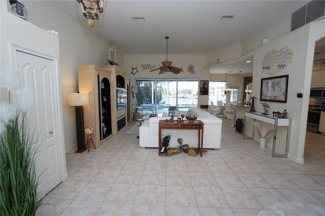 kitchen with range with electric cooktop, crown molding, light tile patterned flooring, and ceiling fan with notable chandelier