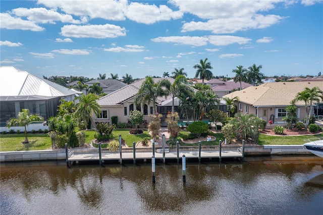 rear view of property featuring a water view and a lawn