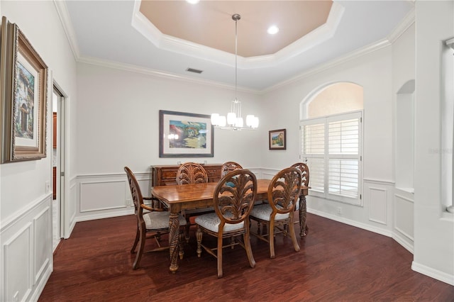 dining space with a chandelier, dark hardwood / wood-style flooring, a tray ceiling, and crown molding