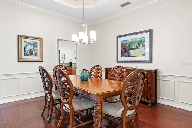 dining room featuring crown molding, dark hardwood / wood-style flooring, and a chandelier