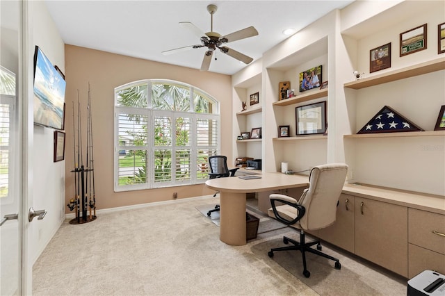 carpeted home office featuring ceiling fan and built in features