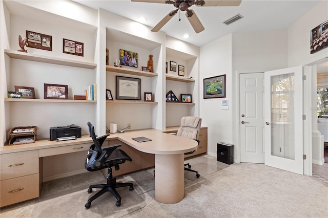 office space with light carpet, built in desk, built in features, and ceiling fan