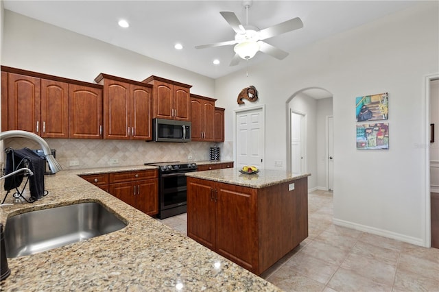 kitchen with light stone countertops, tasteful backsplash, ceiling fan, sink, and black range with electric stovetop