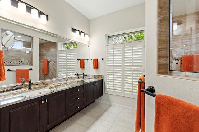 bathroom with tile patterned floors, vanity, and a tile shower