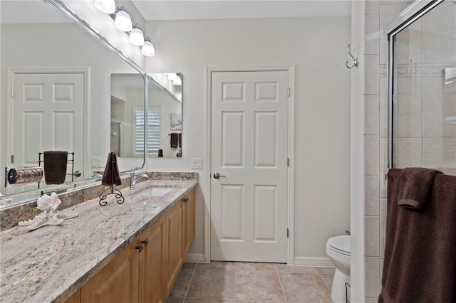 bathroom with tile patterned floors, vanity, toilet, and a shower with door